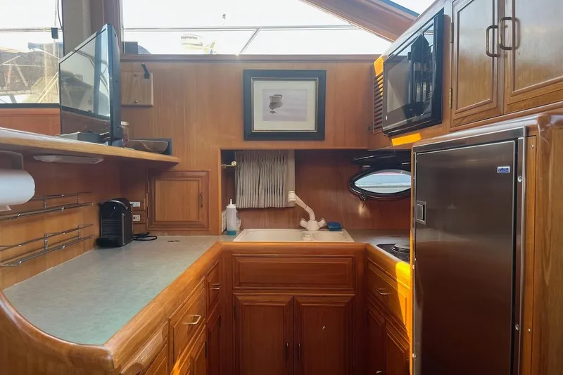 Slide: The Image of Cozy kitchen in 1993 Ocean Alexander 460 yacht with wood cabinetry and modern appliances. - 45