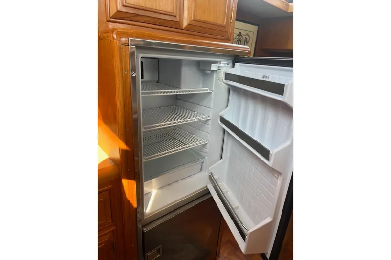 Slide: The Image of Open refrigerator inside 1993 Ocean Alexander 460 yacht, showcasing spacious interior and shelving. - 46