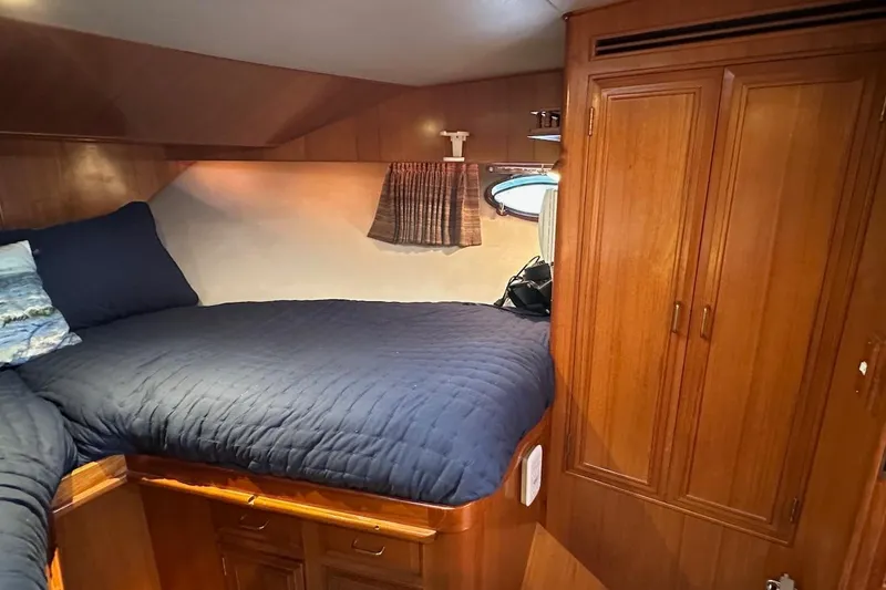 Slide: The Image of Cozy cabin interior of 1993 Ocean Alexander 460 yacht with wooden furnishings and blue bedding. - 49