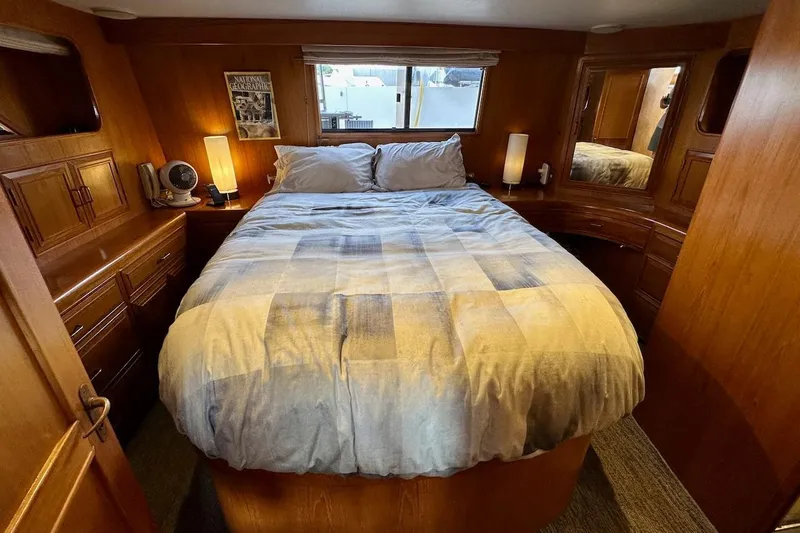 Slide: The Image of Cozy bedroom in 1993 Ocean Alexander 460 yacht with wood paneling and soft lighting. - 52