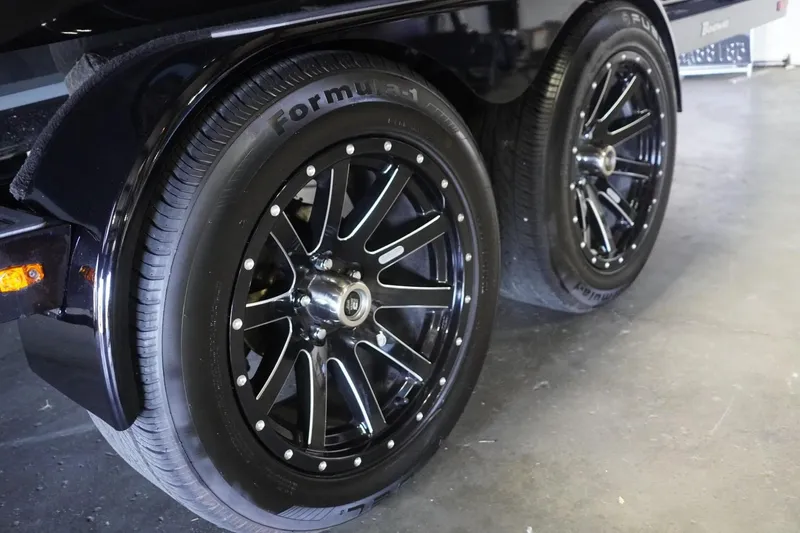 Slide: The Image of 2024 MB B52 23 Classic black wheels with Formula 1 tires in a garage setting. - 5