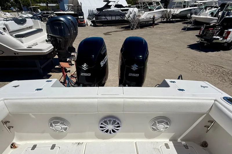 Slide: The Image of 2002 Intrepid 323 Cuddy with twin Suzuki 250 engines in a boatyard setting. - 15