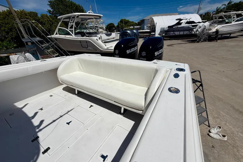 Slide: The Image of 2002 Intrepid 323 Cuddy boat with Suzuki engines, docked in a marina. - 16