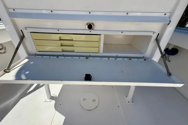 Slide: The Image of Storage compartment on a 2002 Intrepid 323 Cuddy boat, featuring drawers and open space. - 19