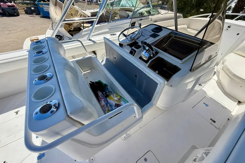 Slide: The Image of 2002 Intrepid 323 Cuddy boat interior with helm, seating, and storage compartments. - 20