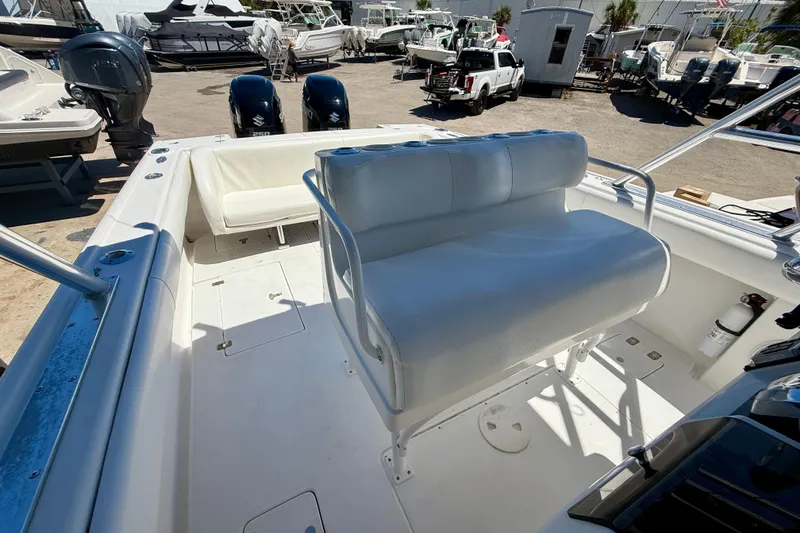 Slide: The Image of 2002 Intrepid 323 Cuddy boat interior with seating and dual outboard motors. - 21