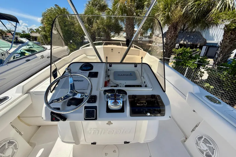 Slide: The Image of 2002 Intrepid 323 Cuddy boat cockpit with steering wheel and navigation equipment. - 24