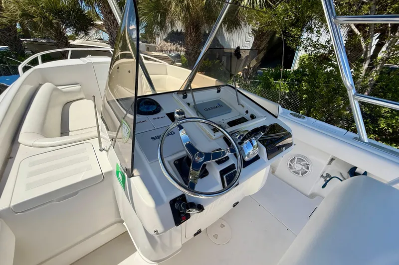 Slide: The Image of 2002 Intrepid 323 Cuddy boat cockpit with steering wheel and navigation equipment. - 25