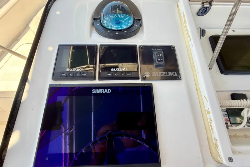 Slide: The Image of Control panel of a 2002 Intrepid 323 Cuddy boat with Suzuki and Simrad displays. - 28