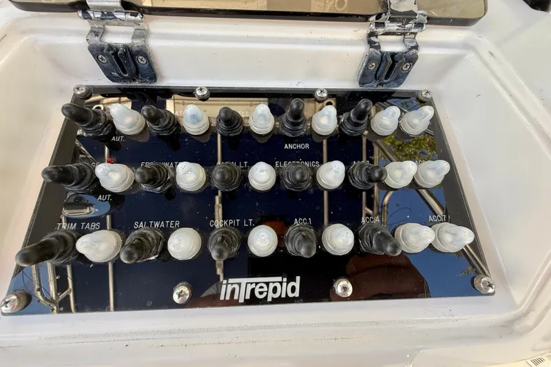 Slide: The Image of Control panel of a 2002 Intrepid 323 Cuddy boat with labeled switches. - 29