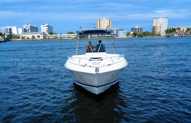 Slide: The Image of 2002 Intrepid 323 Cuddy boat on water with city skyline in background. - 3