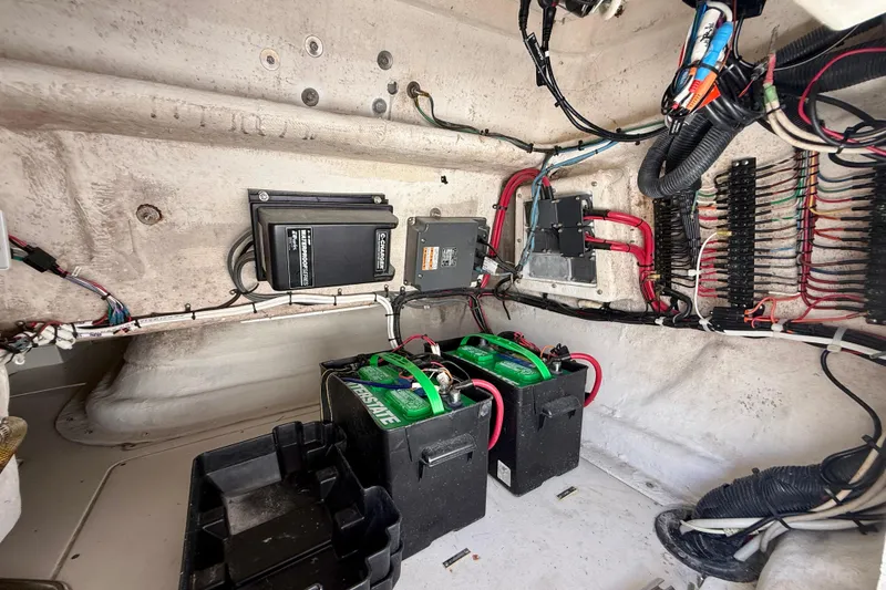 Slide: The Image of Electrical system inside a 2002 Intrepid 323 Cuddy boat, featuring batteries and wiring. - 30
