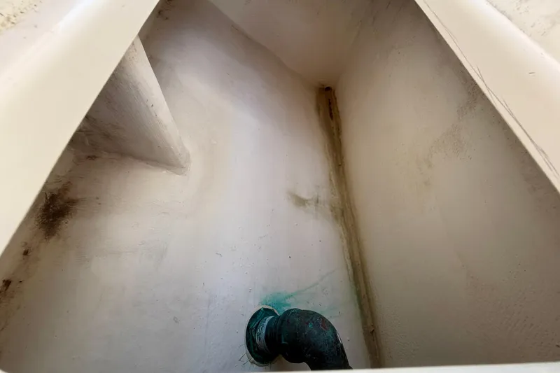 Slide: The Image of Interior view of a 2002 Intrepid 323 Cuddy boat compartment with visible pipe. - 32