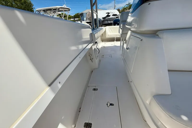 Slide: The Image of 2002 Intrepid 323 Cuddy boat interior, featuring white seating and storage compartments. - 34