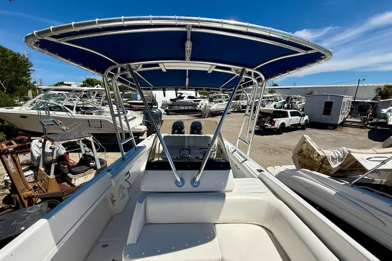 Slide: The Image of 2002 Intrepid 323 Cuddy boat with blue canopy in a marina setting. - 35