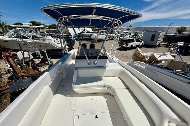 Slide: The Image of 2002 Intrepid 323 Cuddy boat with blue canopy, docked in a marina under clear skies. - 36