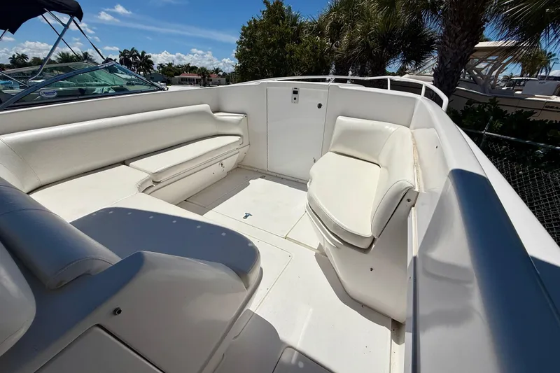 Slide: The Image of 2002 Intrepid 323 Cuddy boat interior with white seating and open deck space. - 38