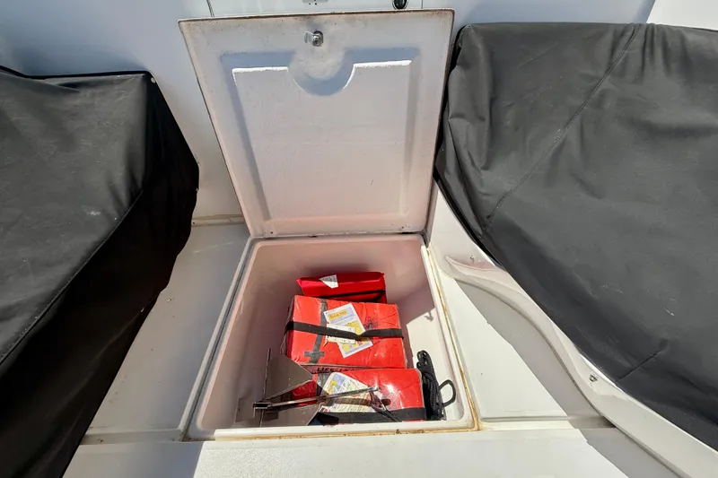Slide: The Image of Open storage compartment on 2002 Intrepid 323 Cuddy boat with life jackets and anchor. - 39
