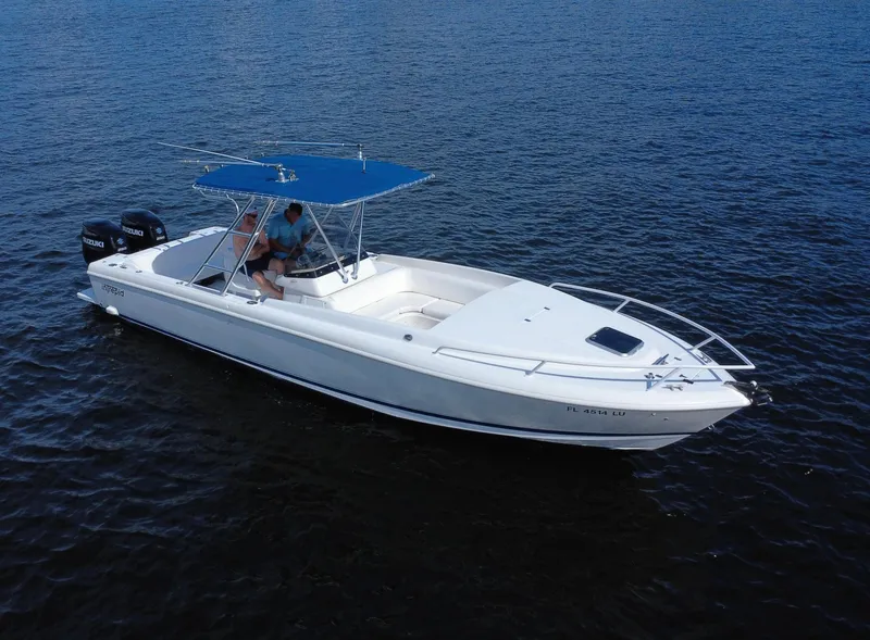 Slide: The Image of 2002 Intrepid 323 Cuddy boat with blue canopy on open water. - 4