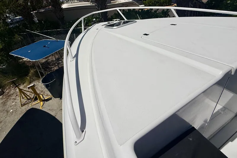 Slide: The Image of 2002 Intrepid 323 Cuddy boat deck, white surface, outdoor setting. - 41