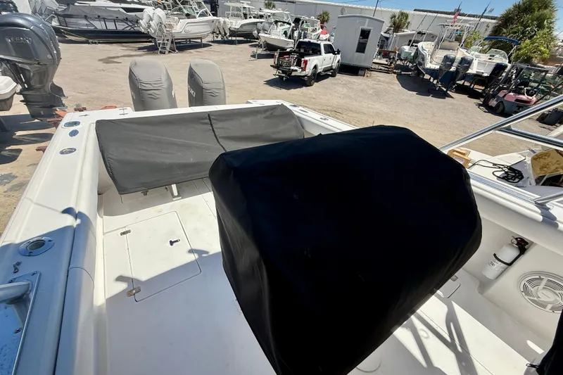 Slide: The Image of 2002 Intrepid 323 Cuddy boat interior with covered seating and equipment in a marina setting. - 43