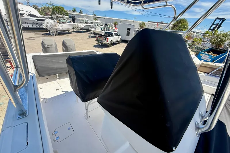 Slide: The Image of 2002 Intrepid 323 Cuddy boat interior with covered seats and equipment, docked at a marina. - 44