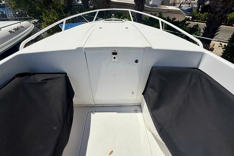 Slide: The Image of 2002 Intrepid 323 Cuddy boat deck with covered seating and storage compartment. - 47