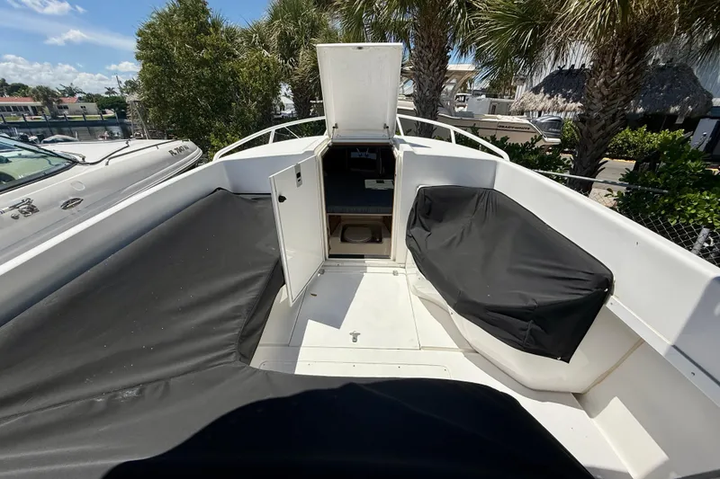 Slide: The Image of 2002 Intrepid 323 Cuddy boat interior with open hatch and covered seating. - 48