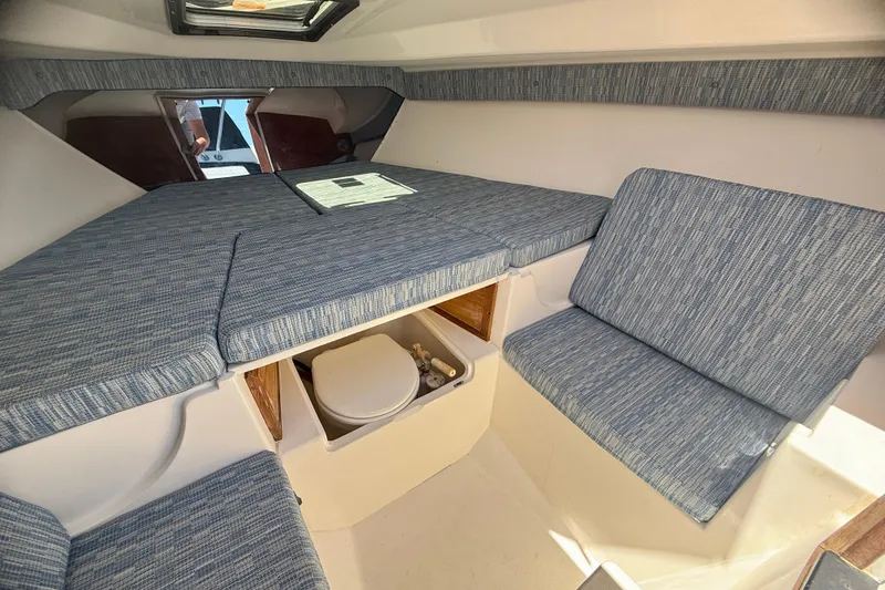 Slide: The Image of 2002 Intrepid 323 Cuddy cabin interior with blue upholstery and compact toilet. - 50