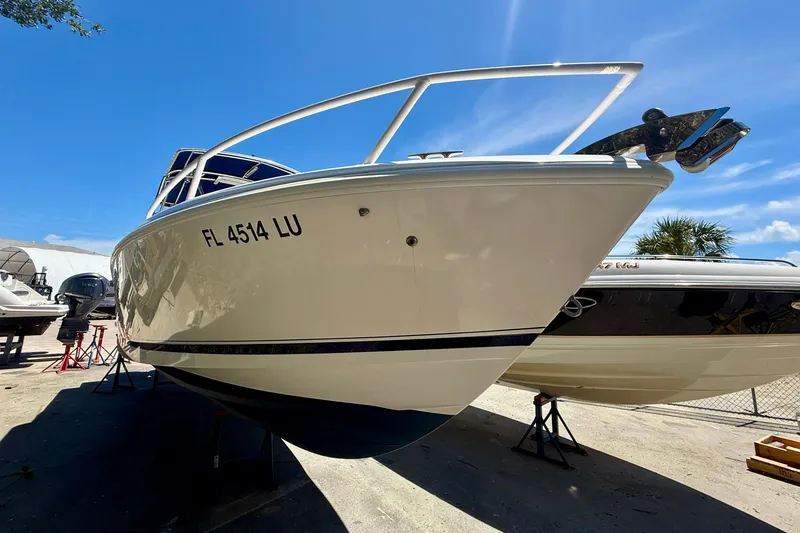 Slide: The Image of 2002 Intrepid 323 Cuddy boat on dry dock under clear blue sky. - 8