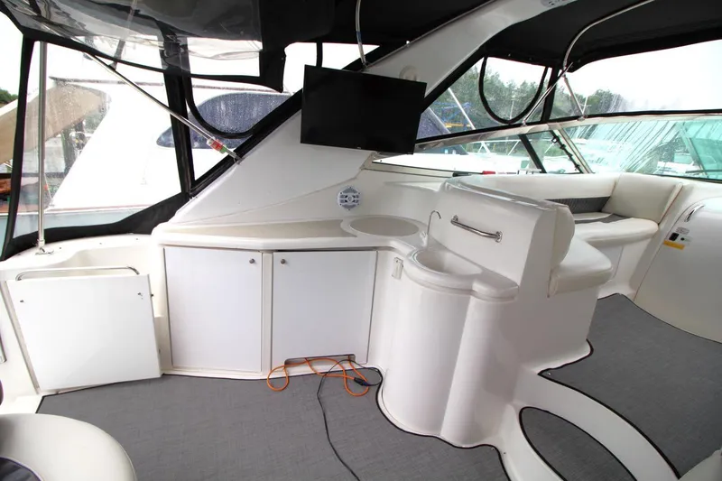 Slide: The Image of 2002 Cruisers Yachts 4270 Express interior with seating, cabinets, and mounted TV. - 14
