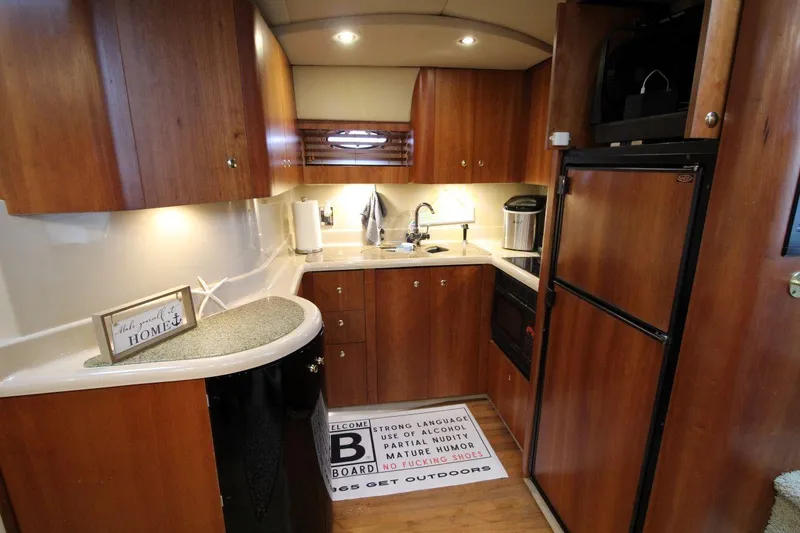 Slide: The Image of Luxurious 2002 Cruisers Yachts 4270 Express kitchen with wood cabinetry and modern appliances. - 23