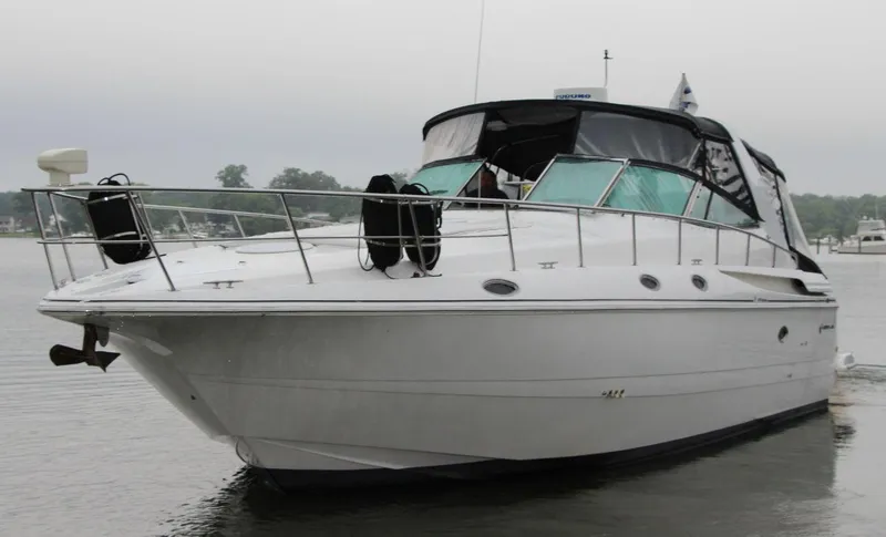 Slide: The Image of 2002 Cruisers Yachts 4270 Express on calm water, showcasing sleek design and luxury features. - 4