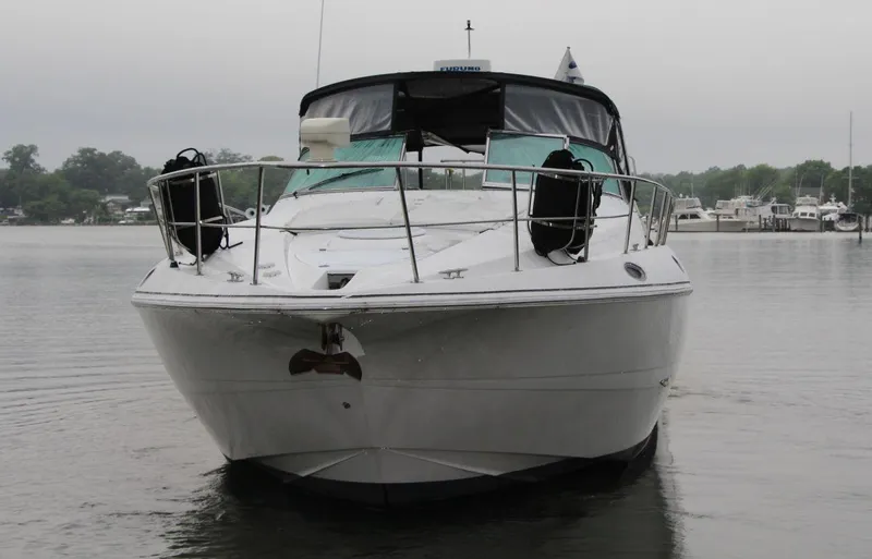 Slide: The Image of 2002 Cruisers Yachts 4270 Express on calm water, front view. - 7