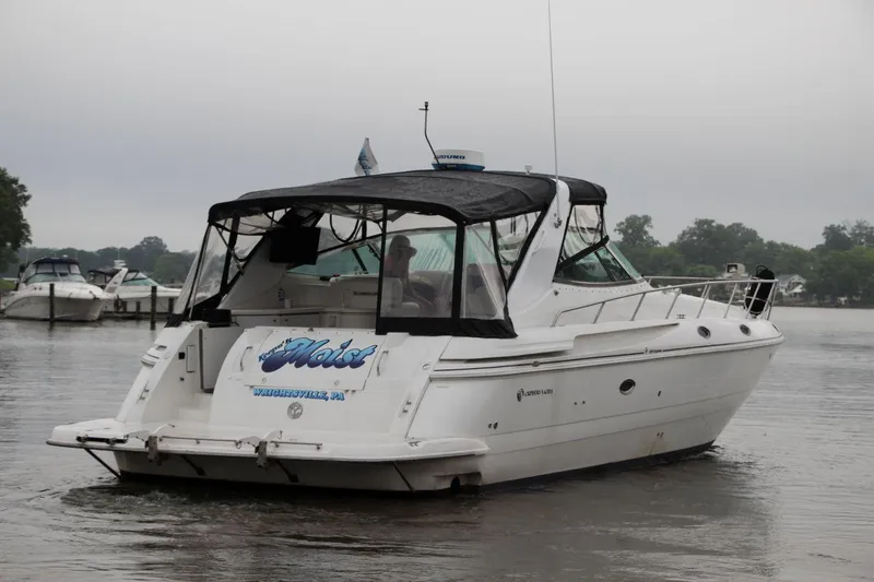 Slide: The Image of 2002 Cruisers Yachts 4270 Express on a calm river, overcast sky. - 11