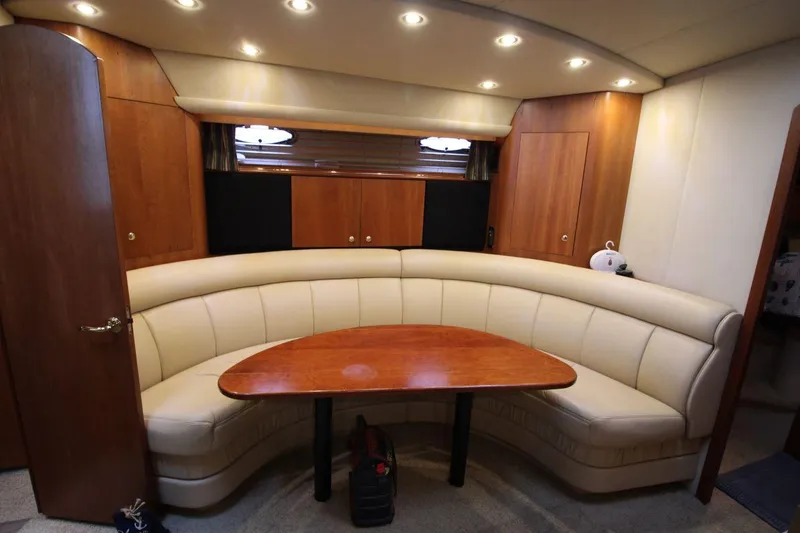 Slide: The Image of Luxurious interior of 2002 Cruisers Yachts 4270 Express with curved seating and wooden table. - 21
