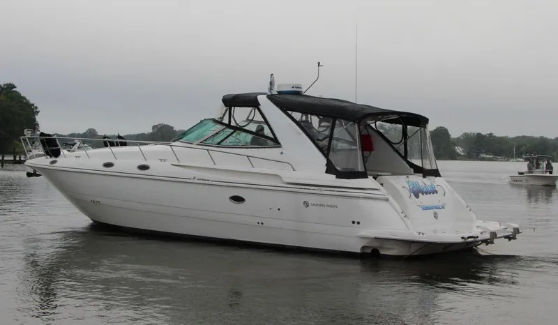 Slide: The Image of 2002 Cruisers Yachts 4270 Express boat on calm water, overcast sky. - 5