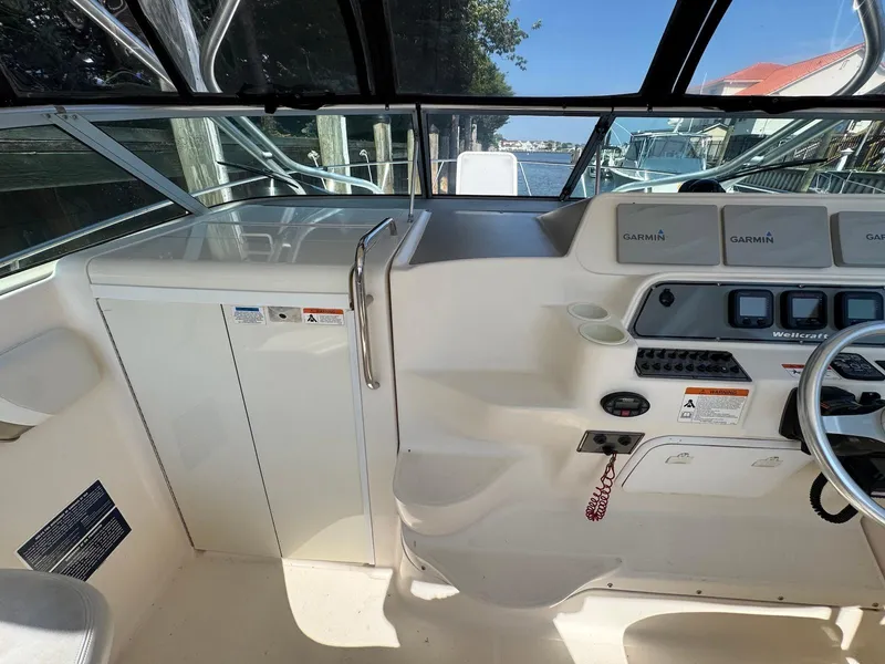 Slide: The Image of 2005 Wellcraft 290 Coastal boat cockpit with Garmin navigation system and steering wheel. - 14