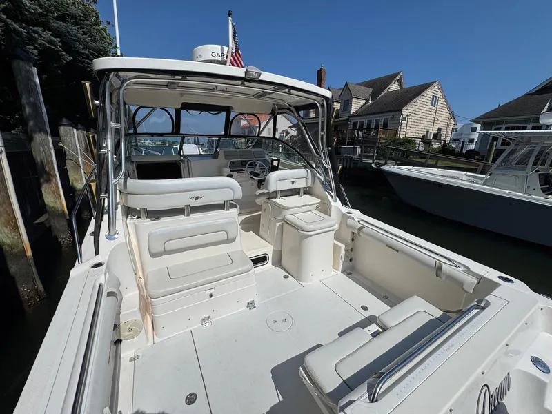 Slide: The Image of 2005 Wellcraft 290 Coastal boat docked, featuring spacious seating and helm area under clear skies. - 15