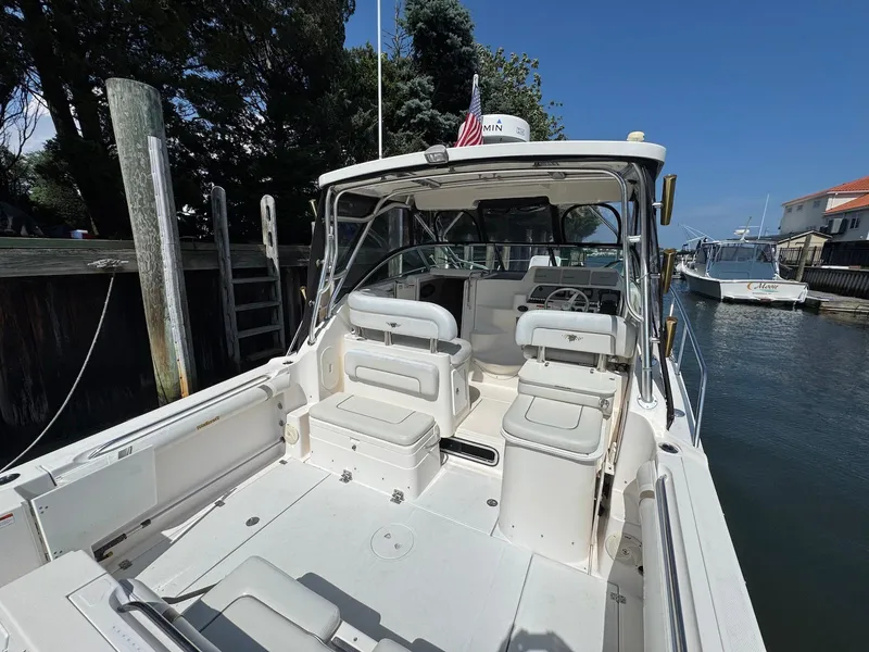 Slide: The Image of 2005 Wellcraft 290 Coastal boat docked, featuring spacious seating and helm area. - 16