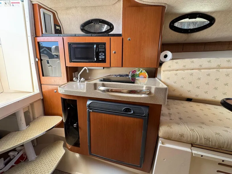 Slide: The Image of 2005 Wellcraft 290 Coastal cabin interior with kitchenette, microwave, and seating area. - 23