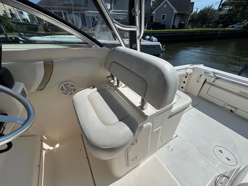 Slide: The Image of 2005 Wellcraft 290 Coastal boat interior with cushioned seating and steering wheel. - 6