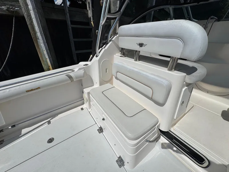 Slide: The Image of 2005 Wellcraft 290 Coastal boat interior with white cushioned seating and storage compartments. - 8