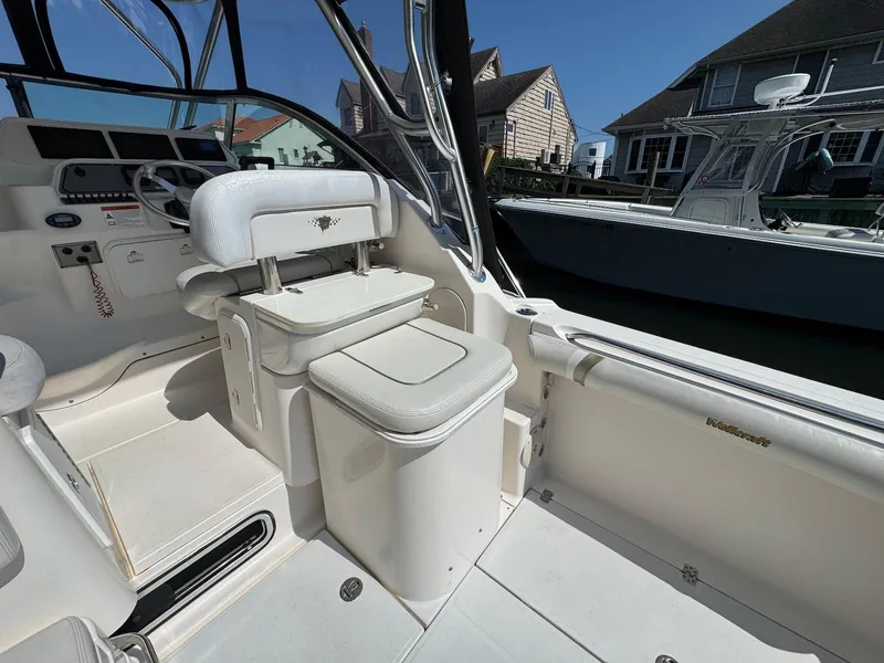 Slide: The Image of 2005 Wellcraft 290 Coastal boat interior with helm and seating, docked near houses. - 9