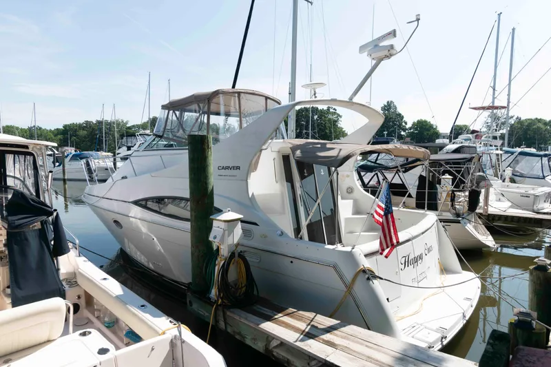 Slide: The Image of 1997 Carver 350 Mariner yacht docked at marina with American flag. - 1