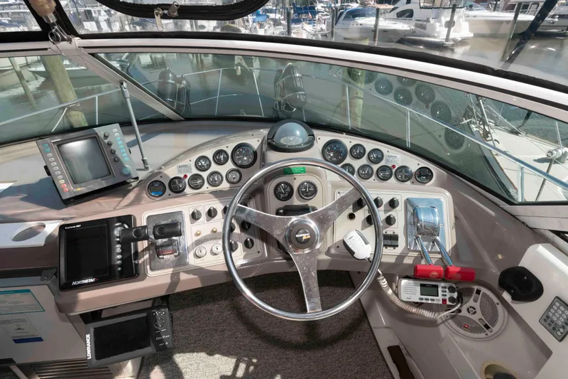 Slide: The Image of 1997 Carver 350 Mariner helm with steering wheel, gauges, and navigation equipment. - 12
