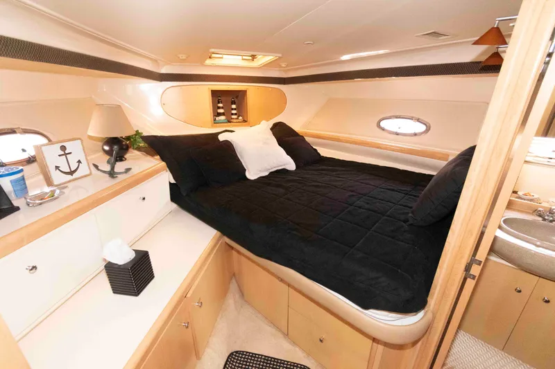 Slide: The Image of 1997 Carver 350 Mariner cabin interior with bed, portholes, and nautical decor. - 19