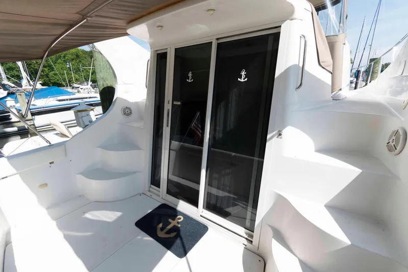 Slide: The Image of 1997 Carver 350 Mariner yacht deck with sliding glass doors and anchor-themed decor. - 4