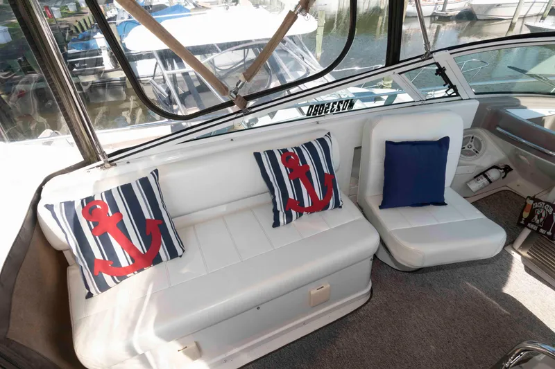 Slide: The Image of 1997 Carver 350 Mariner interior with nautical-themed cushions and white seating. - 10