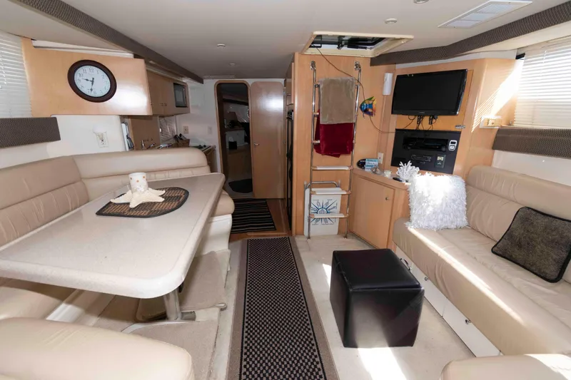 Slide: The Image of Interior of a 1997 Carver 350 Mariner yacht with beige seating and modern amenities. - 17